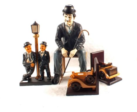 A large seated Stan Laurel figure, Laurel and Hardy lamp post group and wood car bookends