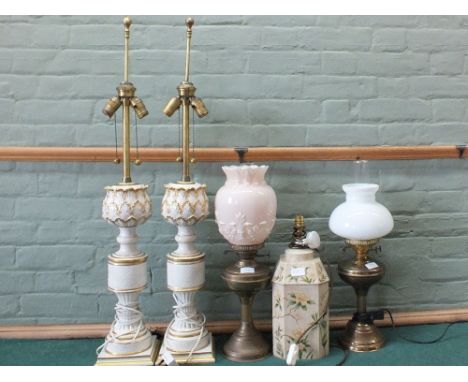 A pair of cream and gilt table lamps, two others and a Brass oil lamp