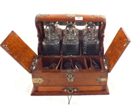 An Oak and Silver plated three bottle tantalus, with lidded compartments and drawers