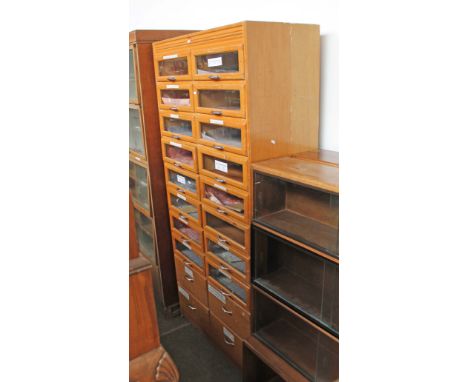 A light wood haberdashery cabinet, comprising 16 glazed drawers above four drawer base, width 91cm, depth 47cm &amp; height 1