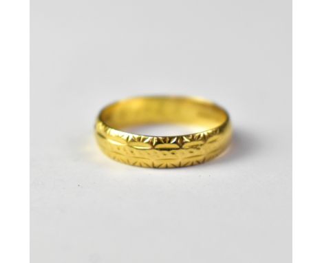 An 18ct gold band ring, with repeating pattern, size S, approx 3.7g.