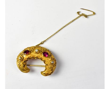 A 19th century gilt or yellow metal crescent-shaped brooch with protruding bezel set red stones, possibly garnets, and three 