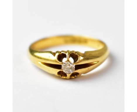 An 18ct gold ring set with central solitaire diamond, within a stylised open claw fitting, with open channel shoulders, stamp