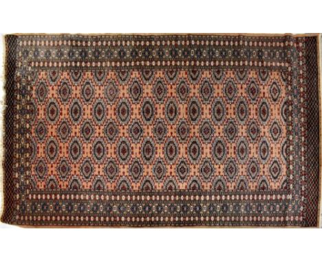 A contemporary woollen peach ground carpet, the central panel with various elephant foot medallions within a stepped geometri