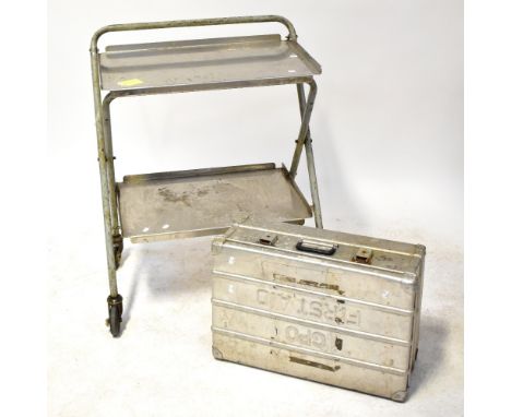 A stainless steel industrial two-tier trolley, 96 x 76 x 49cm, together with a metal trunk with 'First Aid' impressed to the 