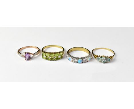 Four 9ct gold dress rings comprising three opals separated by four white stones, size Q, a single claw set amethyst-coloured 