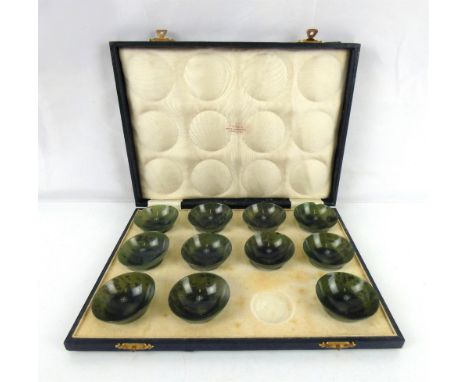 A late 19th/early 20th century set of eleven Chinese spinach jade circular bowls, diameter of each 6cm, in a case retailed by
