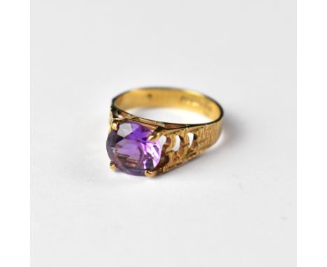 A 9ct gold dress ring with cut amethyst stone and textured shoulders, size J, approx 2.3g.