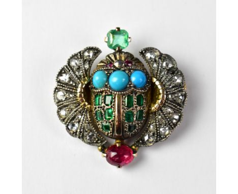 An Art Deco Egyptian-style brooch in the form of a winged scarab, the body encrusted with ten baguette cut emeralds, three tu