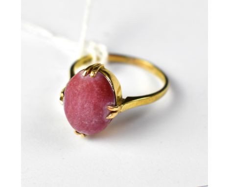 An 18ct gold ring with a four-claw set red stone cabochon, size R, approx 4.8g.