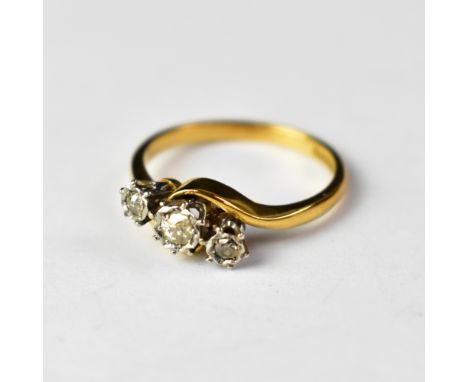 An 18ct gold three-stone diamond ring, the principal diamond approx 0.1ct, flanked by two smaller diamonds, approx 0.05ct, in