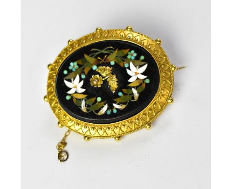 A 19th century mourning brooch with a large oval pietra dura panel depicting a gold centred flower surrounded by a floral gar