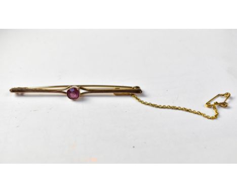 A 9ct gold bar brooch with a bezel set pink stone, with split shoulders, on a split pin brooch, length 6.5cm, with gold safet