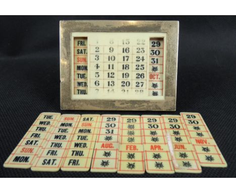 An early 20th century hallmarked silver framed desk calendar, the printed faux ivory dates with interchangeable side panels, 