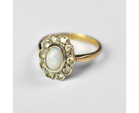 A 9ct gold opal ring, the bezel set white opal within a border of small white stones (possibly topaz), size M, approx 2.7g.