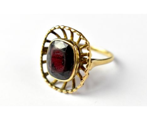 A 9ct gold garnet ring, the bezel set central garnet within an outer caged border, size K, approx 4.5g.