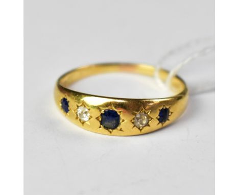 An 18ct yellow gold ring set with three star set sapphires, with two tiny diamonds in between, size S, approx 3.8g.