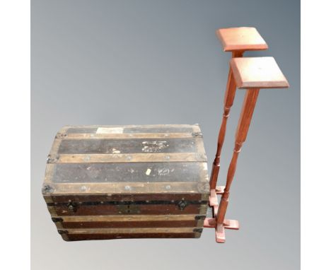 A vintage wooden bound domed shipping trunk together with a pair of wig stands 