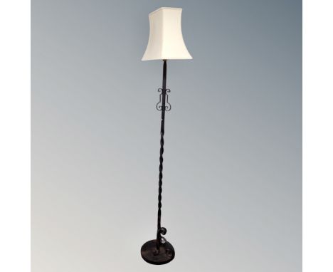 A wrought iron standard lamp with shade 
