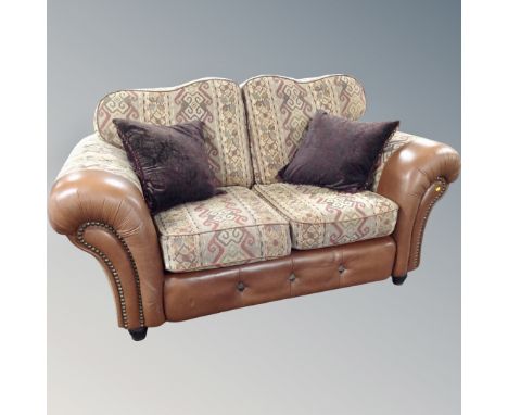 A tan leather and cloth two seater settee with scatter cushions  