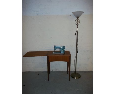 A SINGER SEWING MACHINE AND TABLE WITH A FLOOR STANDING LAMP