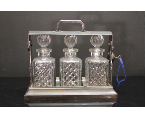 A silver Plated decanter with Locking mechanism and key, complete with three decanter Jars. Labelled underneath Handle, "Silv