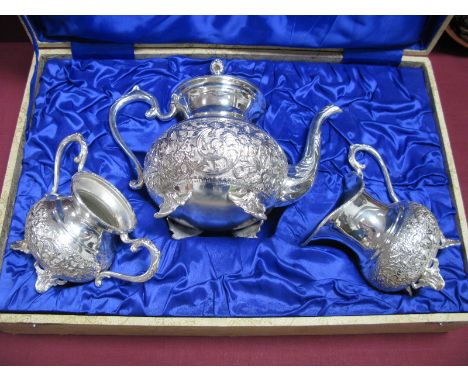 A Vintage Middle Eastern Style Plated Three Piece Tea Set, each detailed in relief with flowerheads and leaf scrolls, raised 