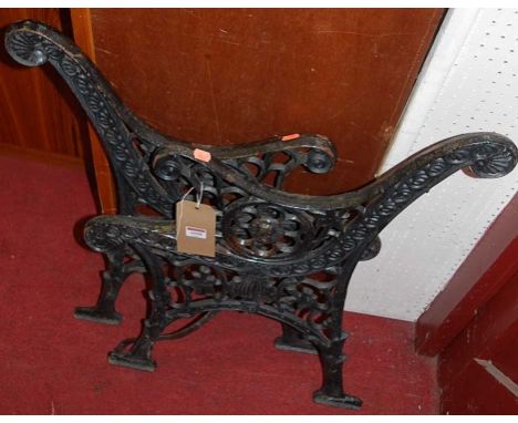 A pair of black painted cast iron bench ends, each of floral pierced and shaped form