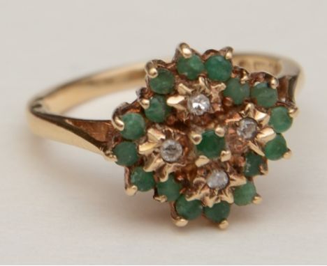 A 9ct gold emerald and diamond cluster ring, the central round cut emerald surrounded by four brilliant cut diamonds and a fu