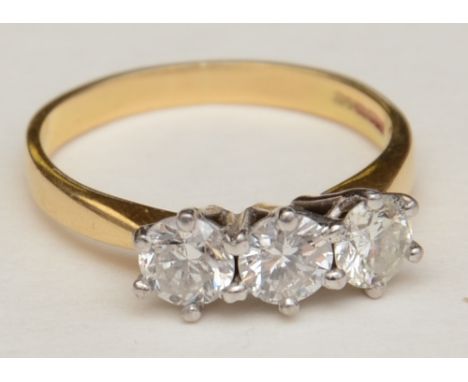 An 18ct gold three stone diamond ring, set with three brilliant cut diamonds in white gold claw setting, approx. 1.20ct in to