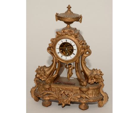 A French gilt mantel clock, with swinging cherub pendulum, the urn finial above white enamel chapter ring and Roman numerals,