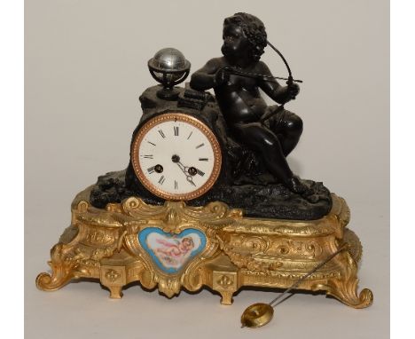 A French gilt mantel clock, depicting Cupid with bow and sevres style panel within gilt base, the clock with white enamel fac