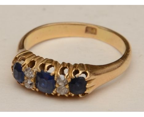 An 18ct gold sapphire and diamond ring, the three oval cut sapphires interspersed by two pairs of diamonds, approx 0.05ct in 