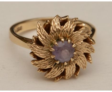 A 9ct gold and amethyst flowerhead ring, the central round cut amethyst set within moulded gold decoration of petals, stamped