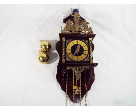 A 20th century Dutch bracket clock, the applied brass chapter ring with Roman numerals, flanked by brass barley twist columns