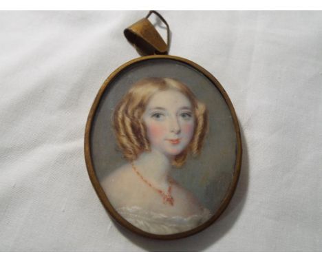 English School oval pendant portrait miniature probably on ivory in gilt metal frame depicting a young woman in 19th century 