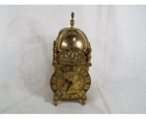 An early 20th century mantel timepiece in the form of a late 17th century English lantern clock, the dial having Roman numera