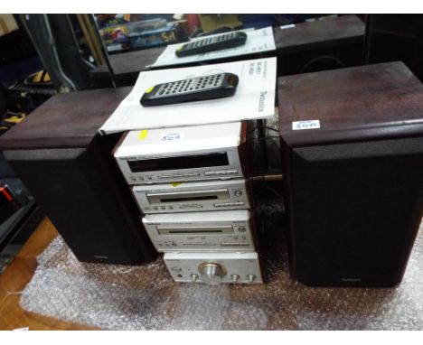 A Technics stereo system with radio tape deck, amplifier, a pair of Technic speakers with remote control and manual, model No