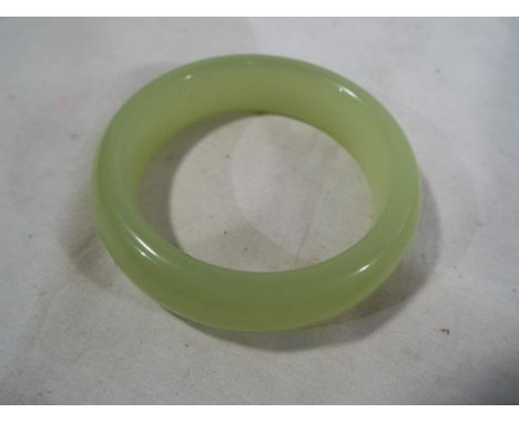 A jade bangle, boxed, approximate weight 8.55 grams. Estimate £40 - £60