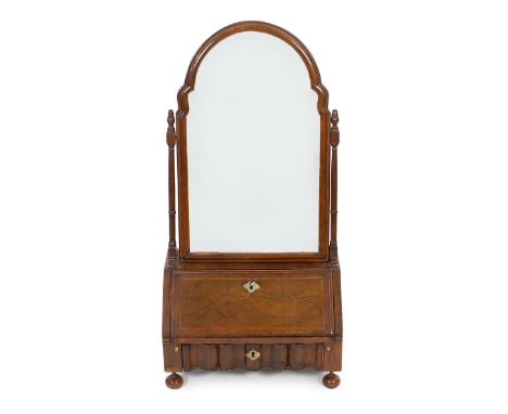 A Queen Anne walnut toilet mirror with arched bevelled plate, fitted interior and serpentine base drawers, on bun feet, 43cm 