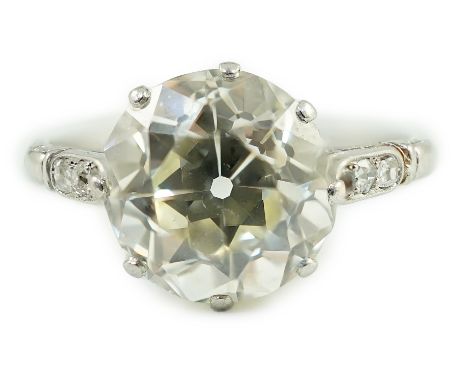 A mid 20th century platinum and single stone diamond ring, with six stone diamond chip set shoulders, the round cut stone wei