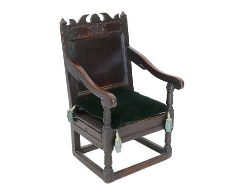 A Charles II oak armchair, of small proportions, monogrammed AM and dated 1682, the seat fitted with a side drawer, 49cm wide