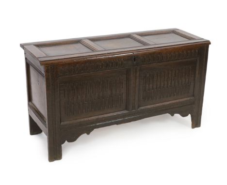 A late 17th century oak coffer, the front panels with egg and dart carving, with triple panel top and stile feet, 132cm wide,