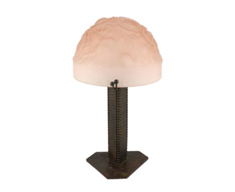 A Muller Freres Art Deco wrought iron and frosted pink glass table lamp, the domed shade moulded with flowers and scrolls, on