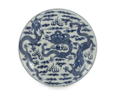 A Chinese blue and white ‘dragon’ dish, Kangxi mark, 19th century, finely painted with a central confronting dragon surroundi