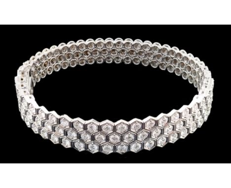 A modern 18ct white gold and diamond cluster set hinged bangle, the diamonds in a hexagonal setting, wit a estimated total we