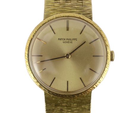 A gentleman's 18ct gold Patek Philippe Calatrava manual wind wrist watch, on an integral Patek Philippe 18ct gold bark bracel