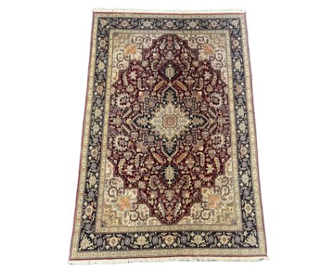 A Tabriz part silk burgundy ground carpet, the central lobed floral medallion within a conforming field and triple border, 29