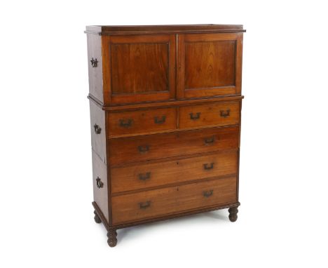 A Victorian teak campaign chest with press cupboard with two panelled doors enclosing a single shelf over two short and three