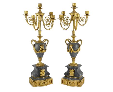 A pair of Louis XVI style ormolu and grey marble five light candelabra with scrolling branches and urn shaped stems on archit